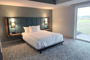 a bedroom with a large bed and a large window at Wingate by Wyndham Geneva at SPIRE Academy in Geneva +23 photos