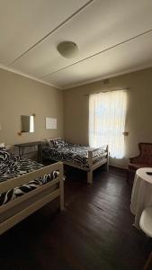 a room with two beds and a window at The Palm Tree in Saldanha