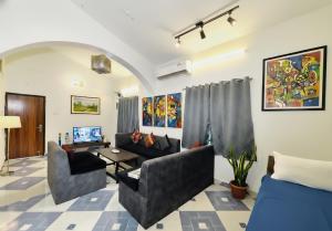 a living room with two couches and a table at The Plix Villa, Vagator in Anjuna
