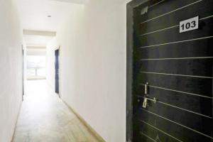 une porte noire avec un numéro dessus dans un couloir dans l'établissement Hotel O Raj Mahal, à Jabalpur