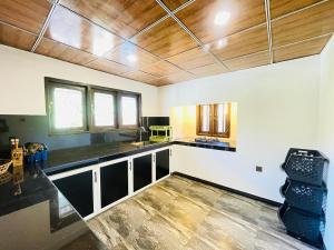 a kitchen with black counter tops and wooden ceilings at Villa Climax in Ahangama