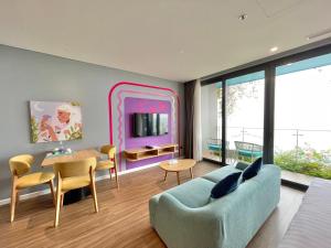 a living room with a blue couch and a table at Flamingo Ibiza Hai Tien managed by Flamingo Hotels and Resorts in Nam Khê