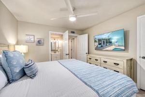 een slaapkamer met een groot bed en een flatscreen-tv bij Honeysuckle - L in Siesta Key +52 foto's