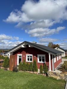 a red house with a black roof at Ferienhaus Fichtelwichtel in Mehlmeisel