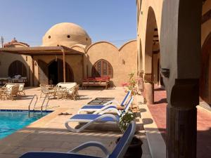 een rij ligstoelen naast een zwembad bij Sultana Palace in ‘Ezbet Abu Ḥabashi