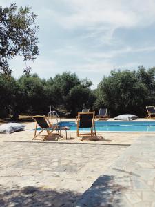 a group of chairs sitting next to a swimming pool at Wunderschönes Ferienhaus In Agios Stefanos in Foútia