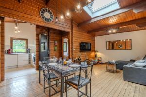 a kitchen and living room with a table and chairs at Le chalet forestier de Guerlande - Disney 20min in Pézarches