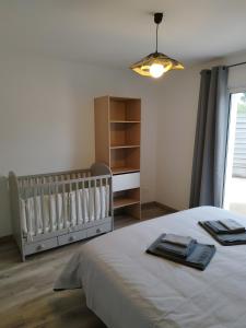 een slaapkamer met een babybedje en een kamer met een raam bij L'Estran qu'Île - Proche plages in LʼÎle-dʼOlonne