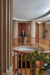 a man standing on a balcony in a building at Main Plaza Suite Tower in Frankfurt/Main +18 photos