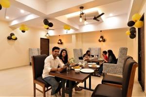 a group of people sitting at a table in a restaurant at FabHotel Blueark in Lucknow