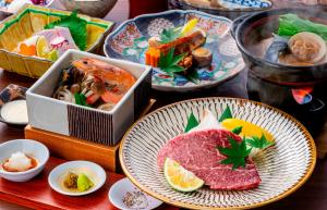 een tafel met borden eten en sushi bij Okamotoya in Beppu