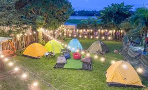 a group of tents sitting in the grass with lights at NV Sport Camping & Hotel - Ho Tram in Xuyên Mộc