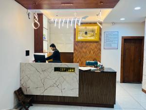 インドールにあるHotel Veronicaのノートパソコンを持って机に座っている男性