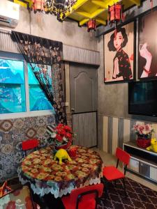 een eetkamer met een tafel met rode stoelen en een tv bij โรงแรม เลิฟ บีเคเค in Amphoe Phra Khanong