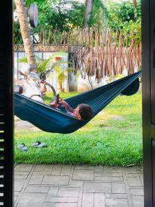 a man lying in a hammock with a motorcycle at Wake N Flow, Ahangama - Kabalana Beach in Ahangama