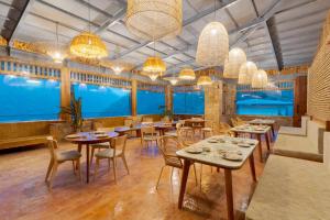 a restaurant with tables and chairs and large windows at Over The World in Rāmgarh