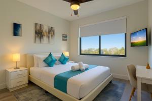 a bedroom with a bed with a desk and a window at Lux place and cozy 3Beds 2Rooms enjoy life in WPB Gym, EV Station Nearby the downtown and beaches in West Palm Beach