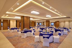 a banquet hall with blue tables and white chairs at Lemon Tree Hotel, Ranchi in Rānchī +61 photos