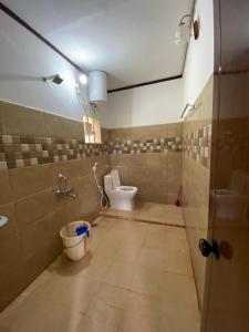 La salle de bains est pourvue de toilettes et d'un seau. dans l'établissement Coorg jungle Cottage, à Kushalanagar