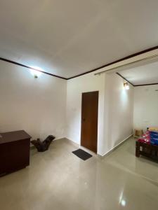 Cette chambre blanche dispose d'une porte et d'une table. dans l'établissement Coorg jungle Cottage, à Kushalanagar 2 autres photos