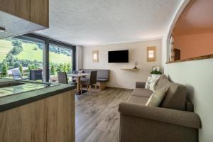 a kitchen and living room with a couch and a table at Alpenappart in Cadipietra