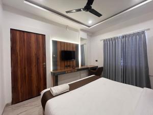 インドールにあるHotel Veronicaの大きなベッドとテレビのある寝室