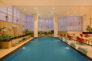 a hotel lobby with a swimming pool and a restaurant at Lemon Tree Hotel, Ranchi in Rānchī