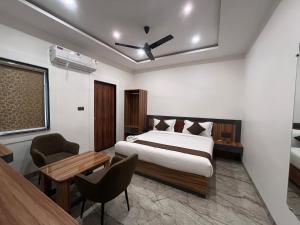 インドールにあるHotel Veronicaのベッドと机とテーブルのある寝室 +98枚の写真