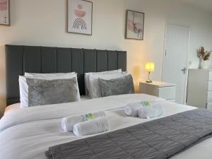 a bedroom with a large white bed with towels on it at Holdsworth House Apartments in Killingbeck