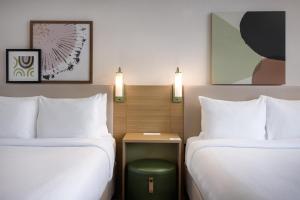 a hotel room with two beds and a table between them at Spark by Hilton Toronto Mississauga in Mississauga +45 photos