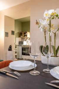 a table with two wine glasses and flowers on it at L'éléhouse Studio Terrasse à RIOM in Riom