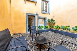 a patio with chairs and tables in front of a building at L'éléhouse Studio Terrasse à RIOM in Riom