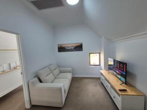 un soggiorno con un divano bianco e una TV di Serenity by the Sea a Mandurah