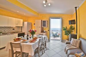a kitchen and dining room with a table and chairs at Casa Conca Azzurra in Costarainera