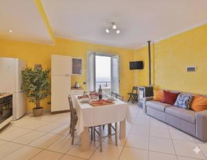 a kitchen and living room with a table and a couch at Casa Conca Azzurra in Costarainera