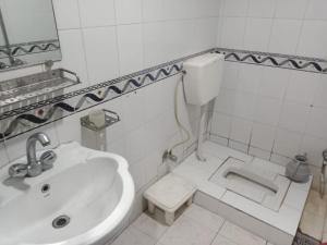 Un baño blanco con lavabo e inodoro. en Hotel The Shalimar, en Lahore