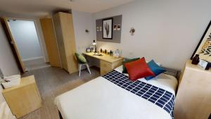 a bedroom with a bed and a desk in it at Guestroom in Malindi