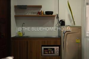 a kitchen with a sink and a refrigerator in a room at BlueHome in Vientiane