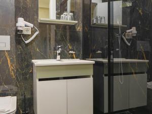 a bathroom with a sink and a shower at Deluna Ümitköy Suite in Çayyolu