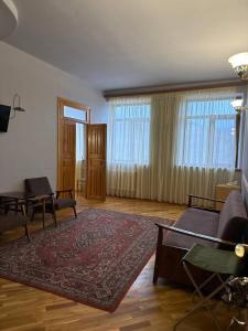 una sala de estar con un sofá y una alfombra en Yeghevnut Hotel, en Goris