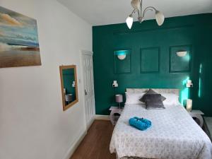 a green bedroom with a bed with a blue object on it at Spacious Double Room in Anfield in Liverpool