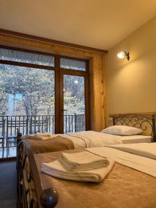 Dos camas en una habitación con ventana. en Yeghevnut Hotel, en Goris