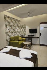 a hotel room with a bed and a couch at Lotus Excutive in Pune +19 photos