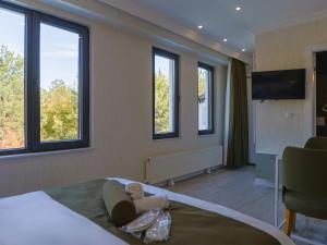 a bedroom with a doll laying on a bed with windows at Deluna Ümitköy Suite in Çayyolu