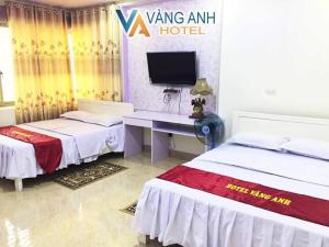 a room with two beds and a desk with a computer at Khách sạn Vàng Anh in Kiên Giáp Ha +3 photos