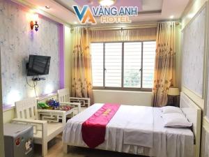 a bedroom with a bed and a desk and a window at Khách sạn Vàng Anh in Kiên Giáp Ha