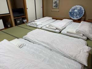 a group of white beds in a room at 天然温泉白川郷の湯 in Shirakawa +26 photos