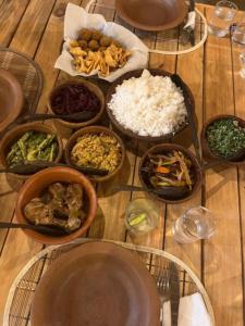 a table with many plates of food on it at Liyara Lodge Sigiriya in Sigiriya