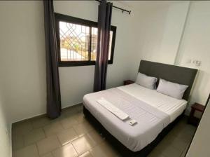 Un dormitorio con una cama grande con ventana. en MC Home, en Yaoundé