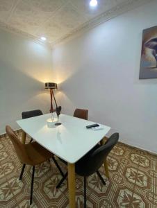 una sala de reuniones con una mesa y sillas blancas en MC Home, en Yaoundé
